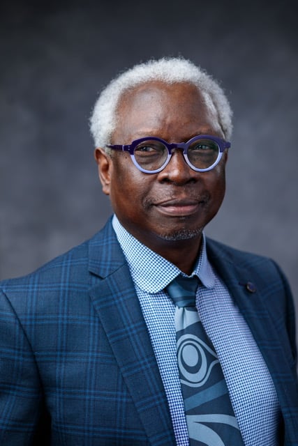 A man in a blue suit and glasses.