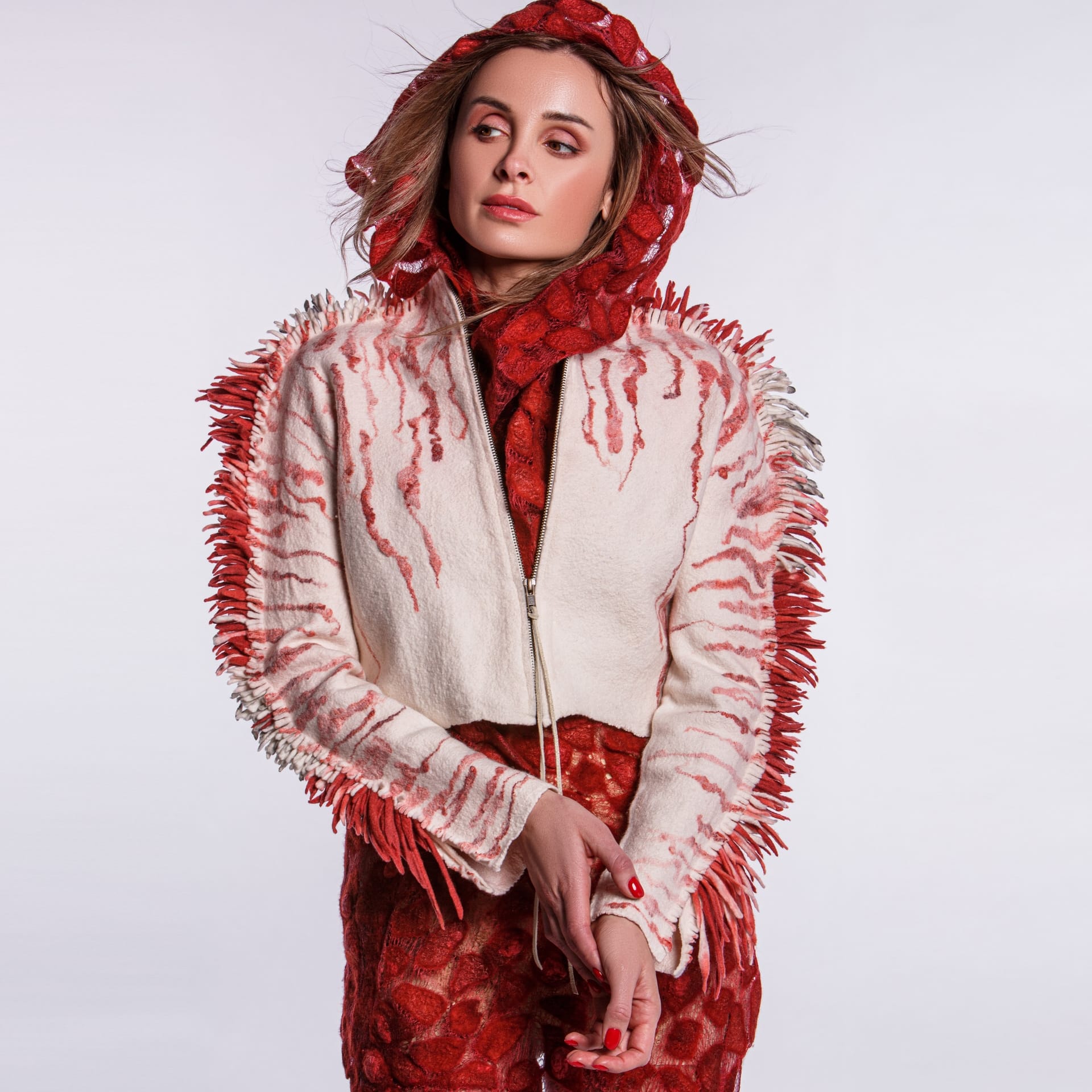 A person wearing a red and white jacket with lots of fuzz.