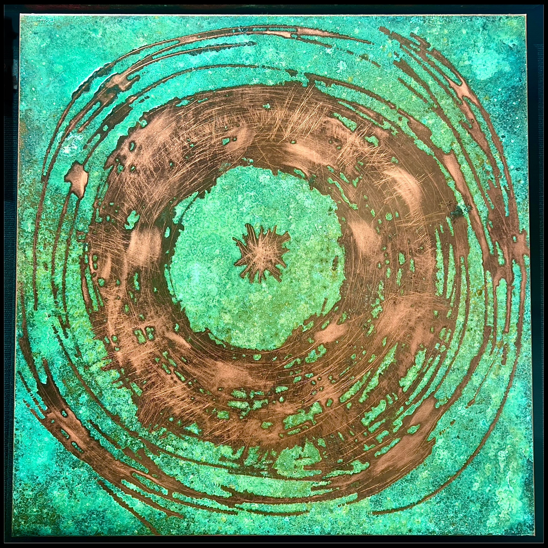 A green and bronze metal artwork.