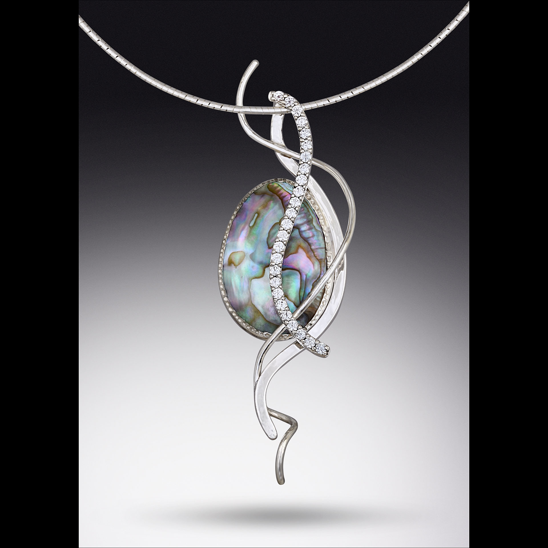 A circle pendant with spiral metal around it.