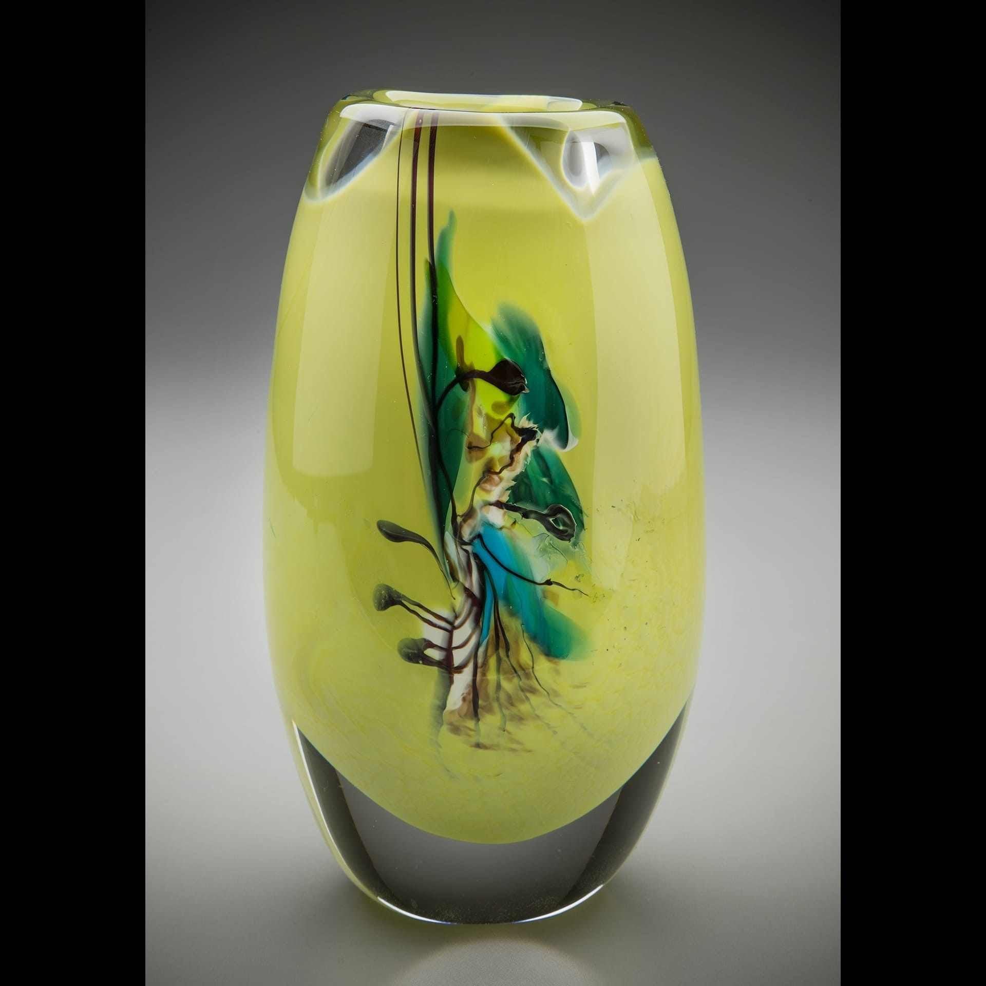 A green vase with abstract designs.