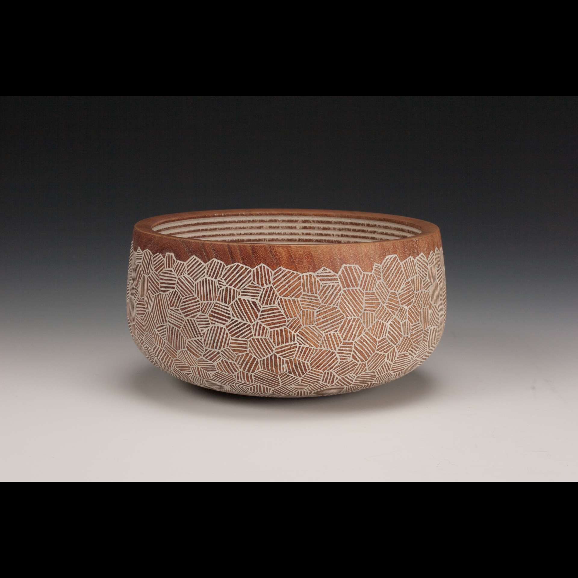 A wooden bowl with patterns on it.