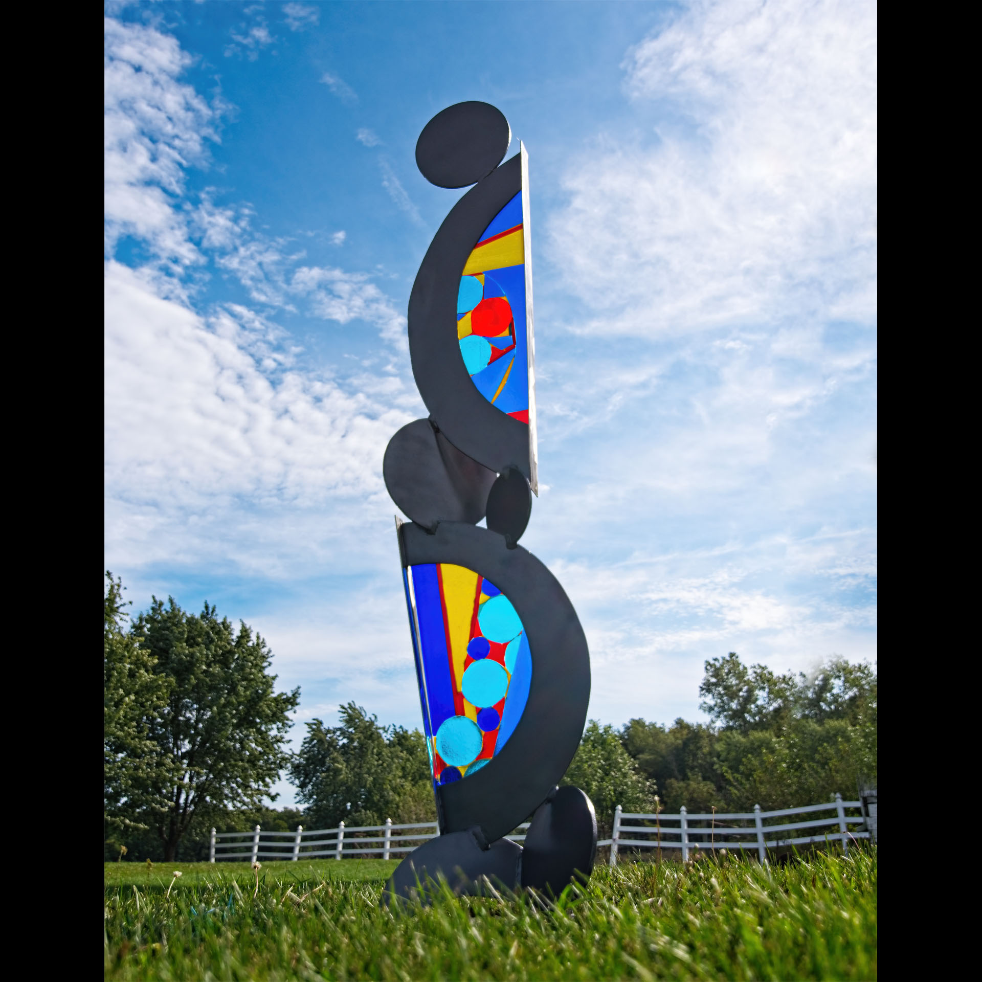 A statue made of black half circles with colors inside them.