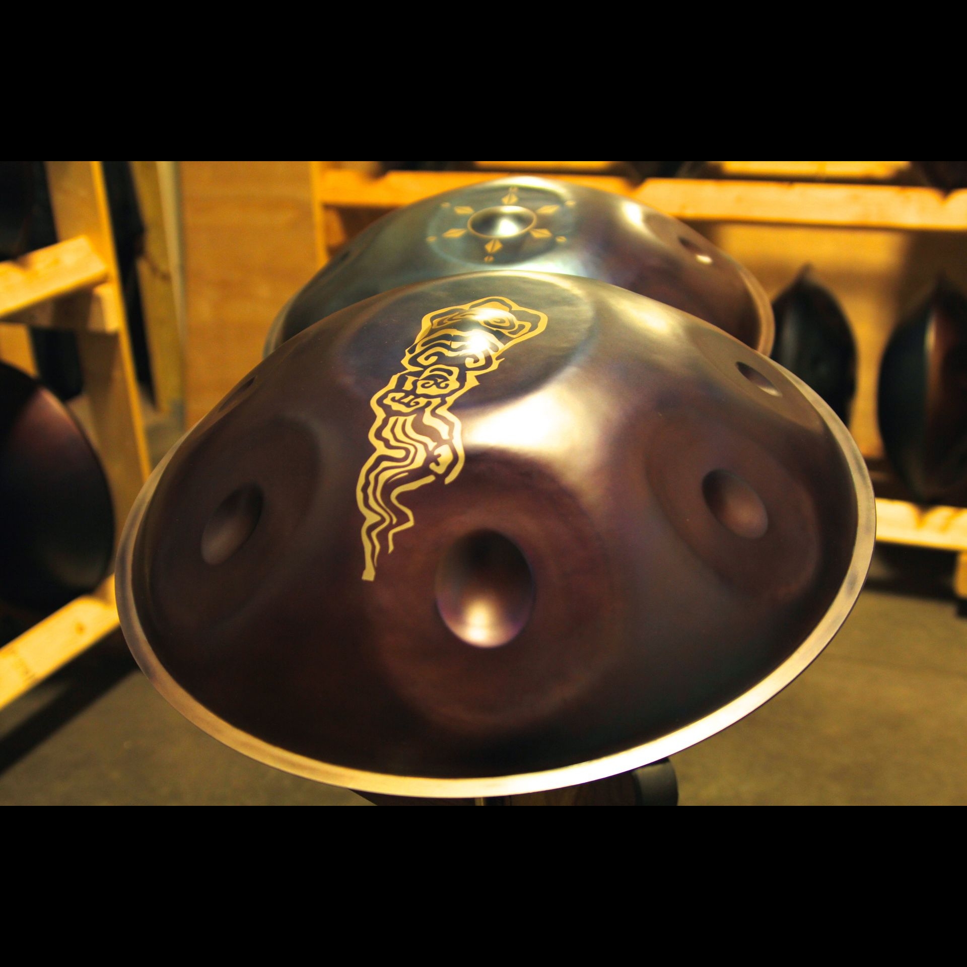 A stee; drum with a small design on it.