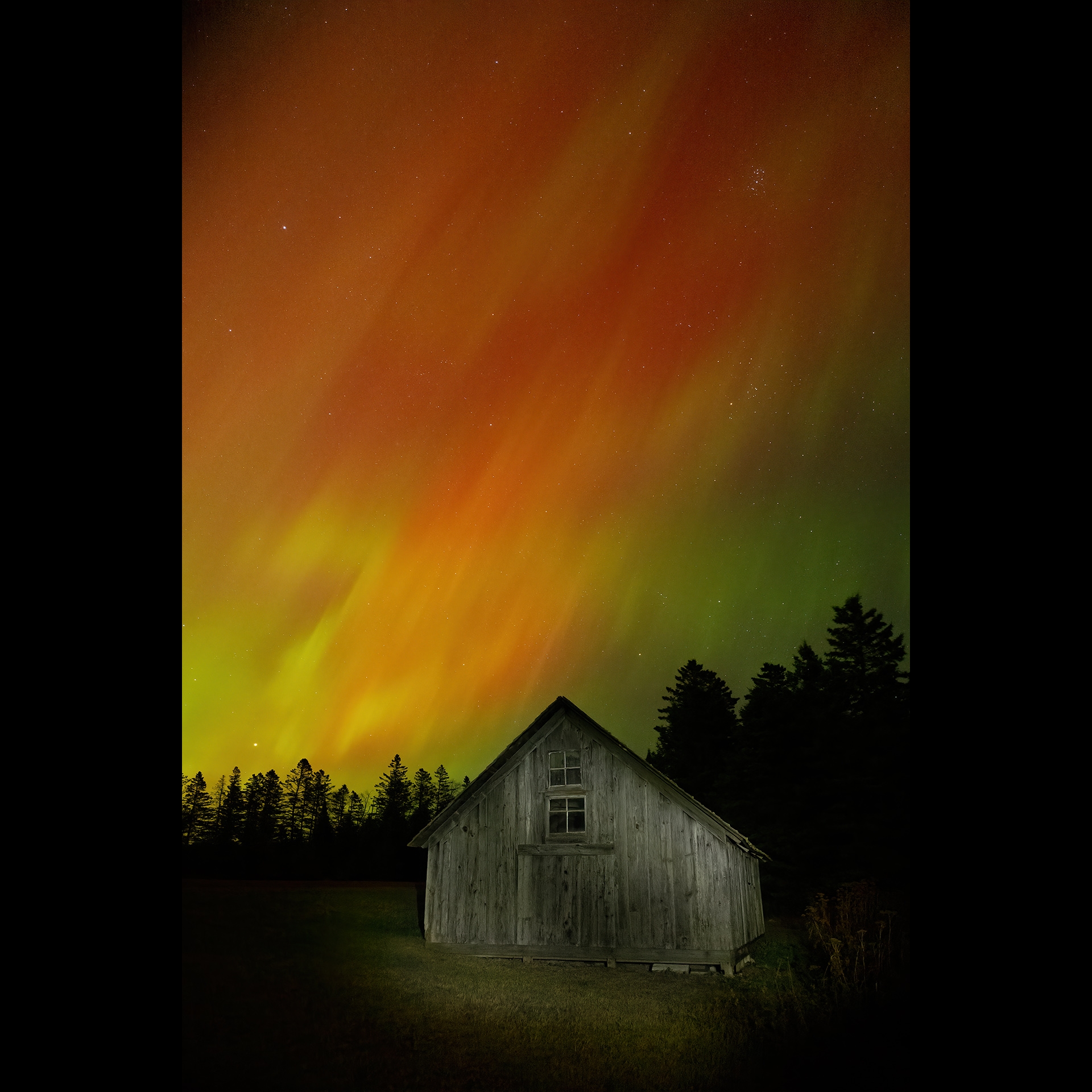 aurora borealis above a house.