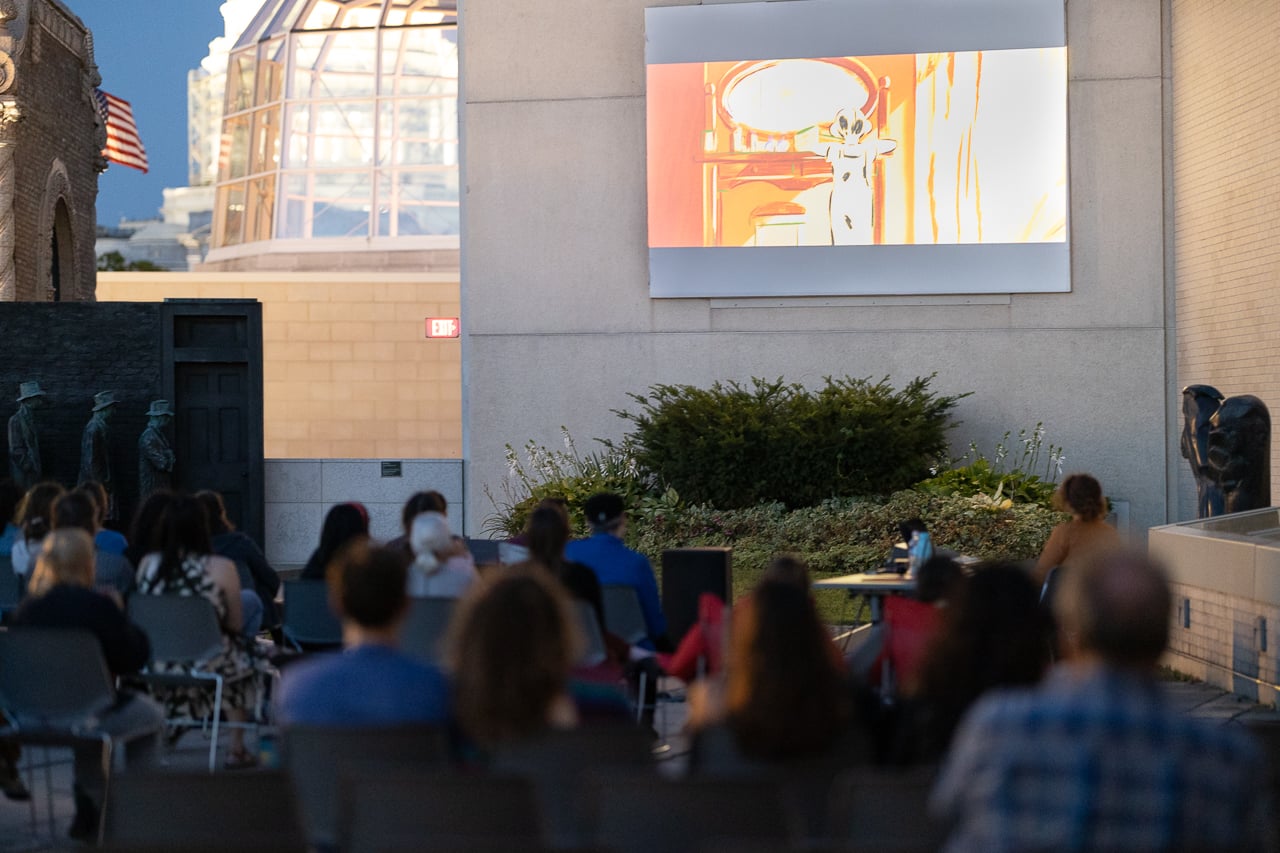 People watching a movie on a rooftop.
