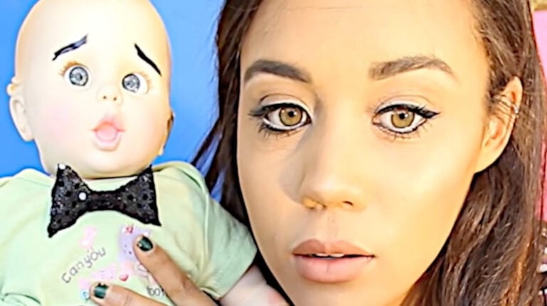 A woman and a doll against a blue background.