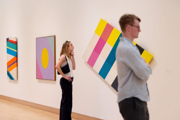Two people looking at abstract art work in a gallery.