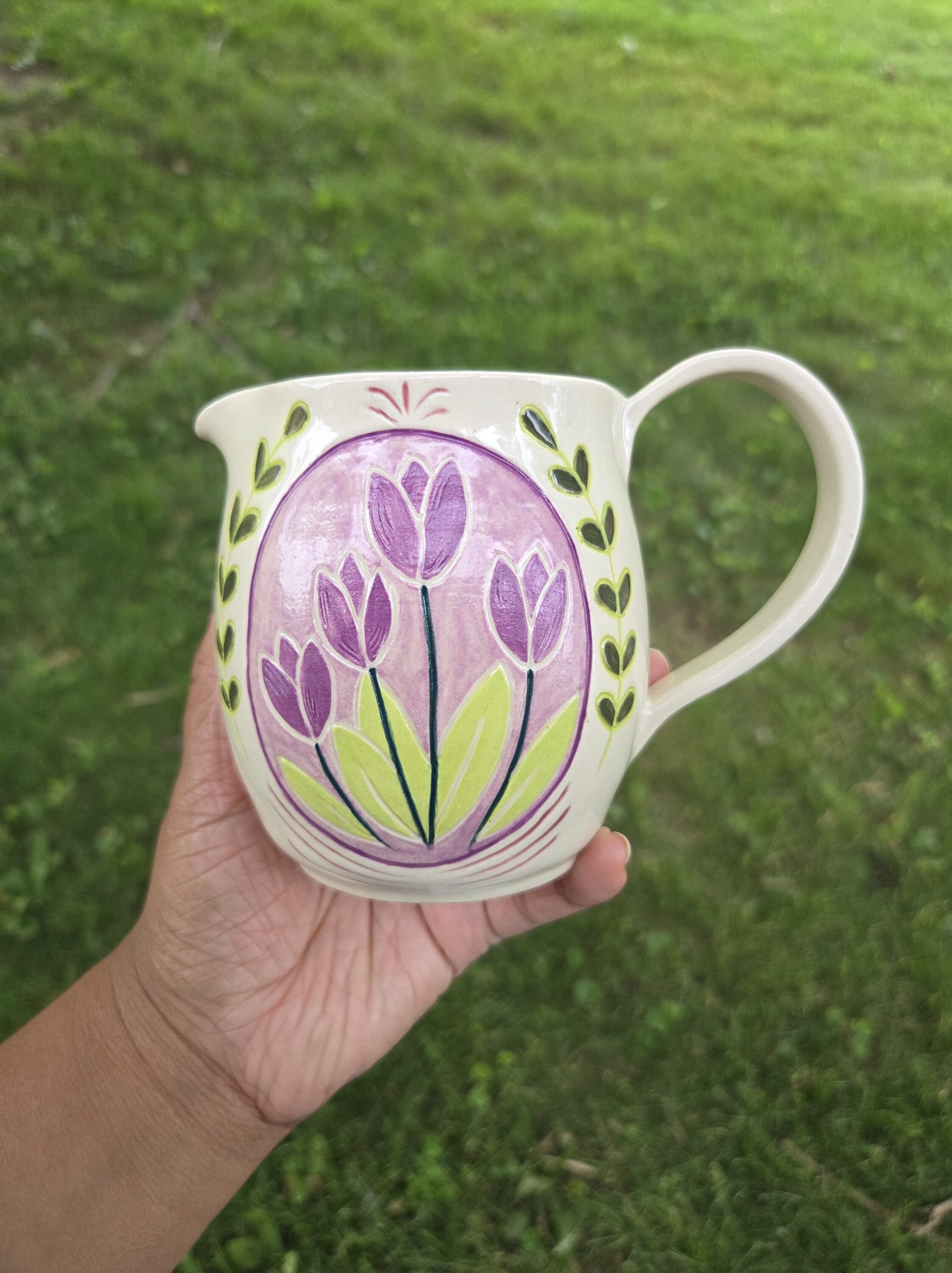A mug with a flower painted on it.