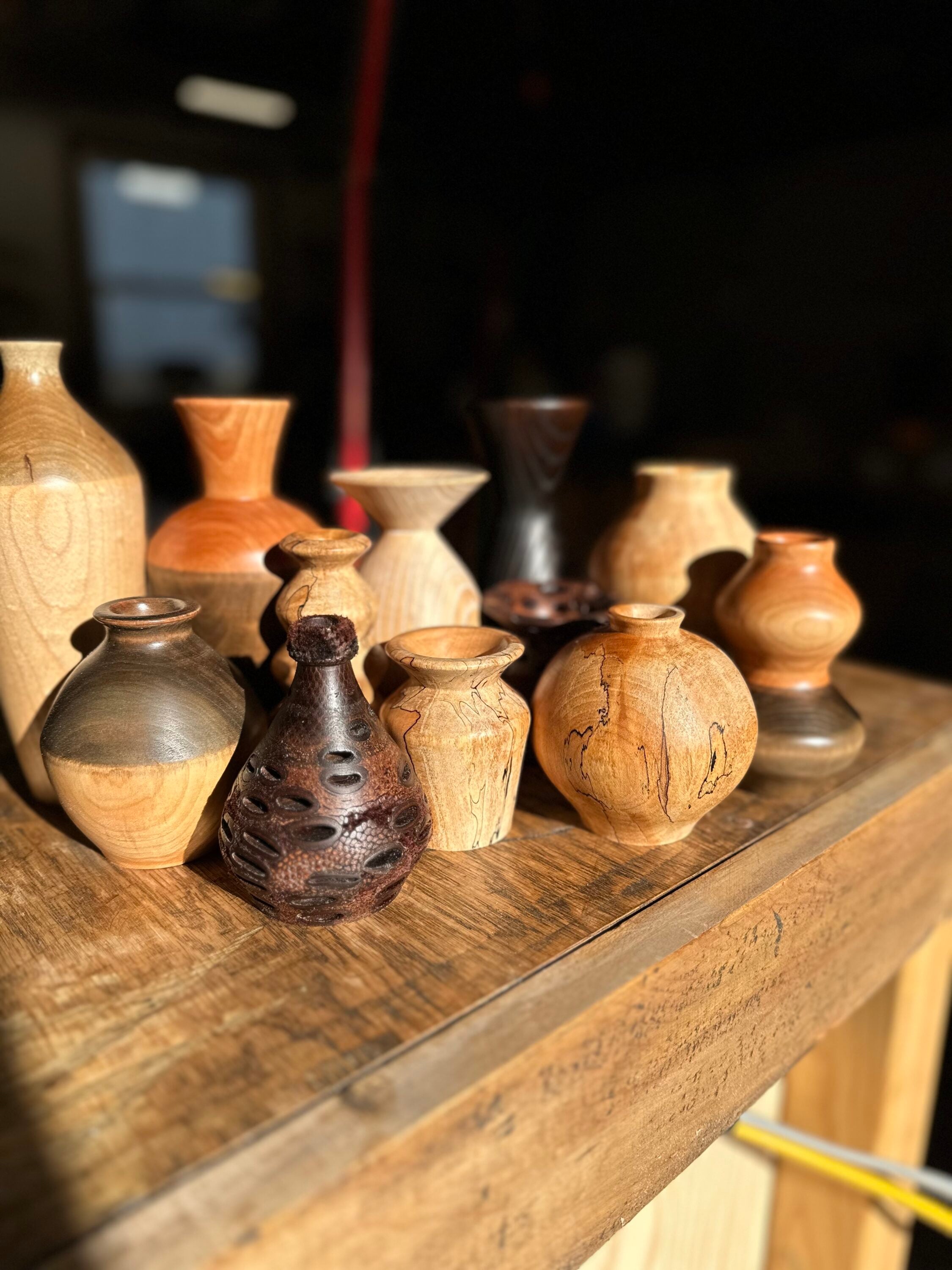 Many wooden vases on a table.