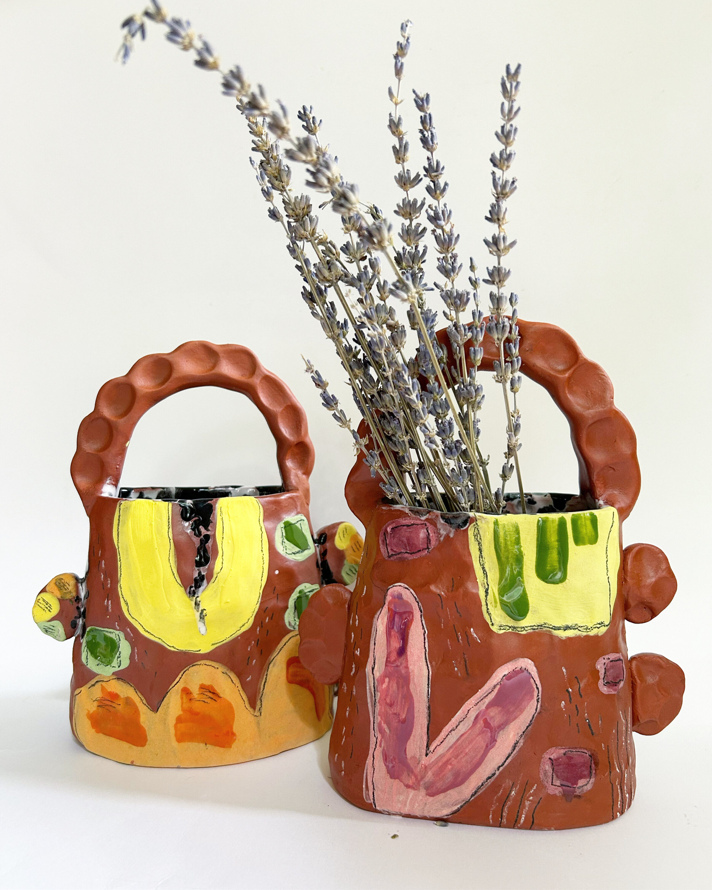 Two ceramic cups with plants in it.